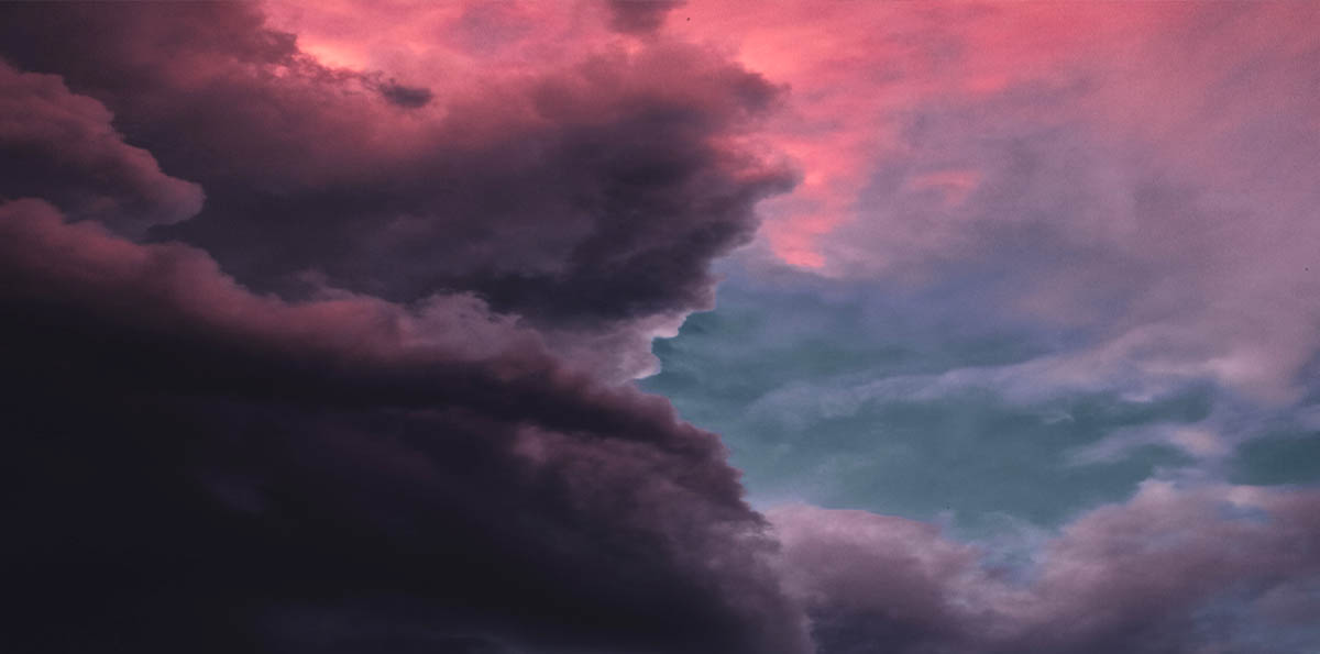 Image of dark clouds looming against a pink sky