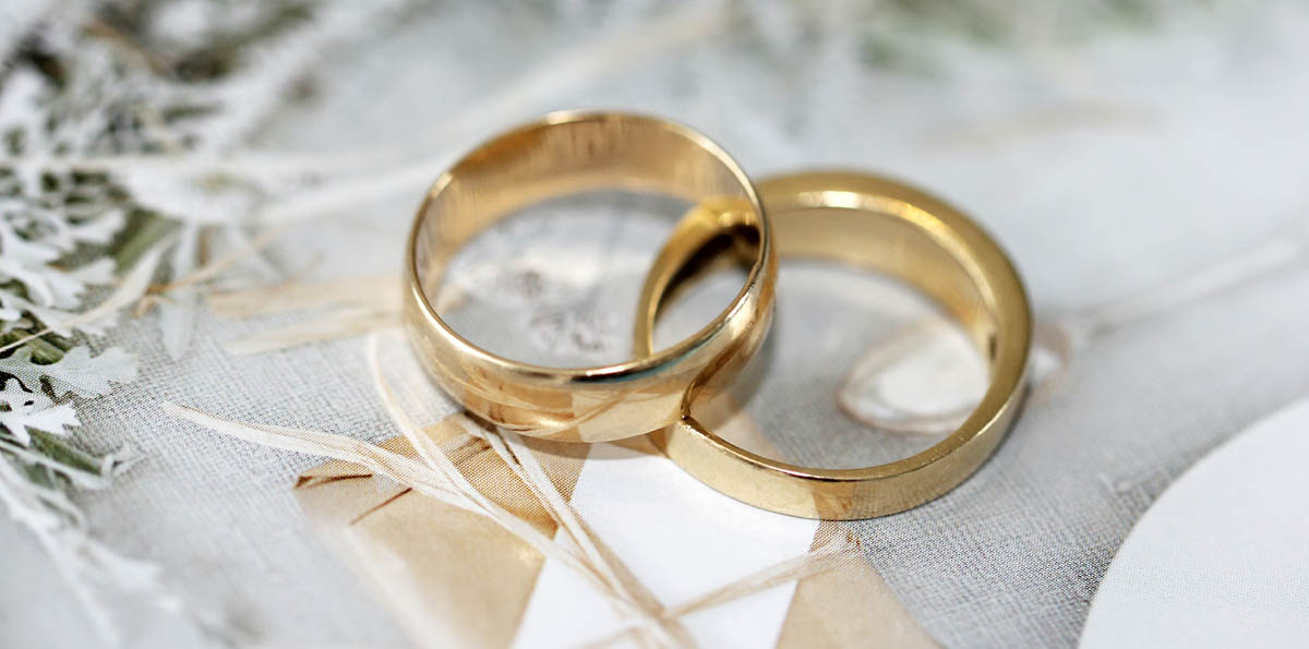 Image of two wedding rings resting on a decorated table